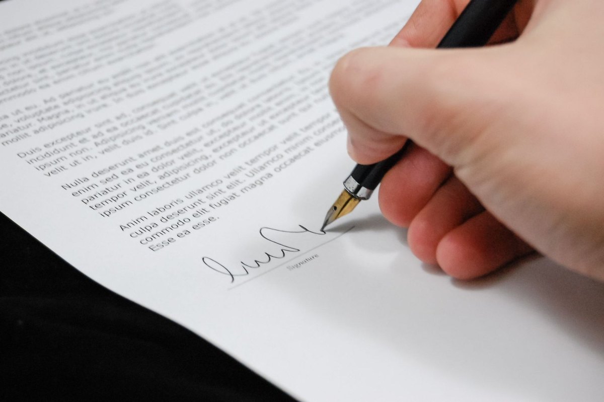 main écrivant sur un document avec un stylo noir