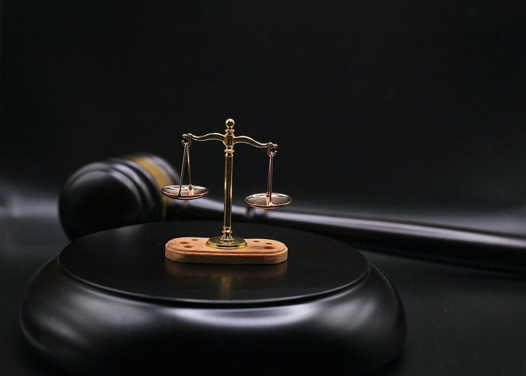 Balance de justice sur un bloc noir, marteau à côté