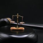 Balance de justice sur un bloc noir, marteau à côté