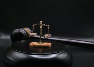 Balance de justice sur un bloc noir, marteau à côté