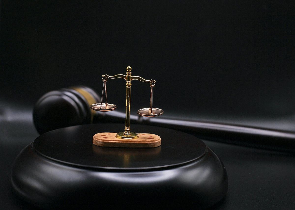 Balance de justice sur un bloc noir, marteau à côté