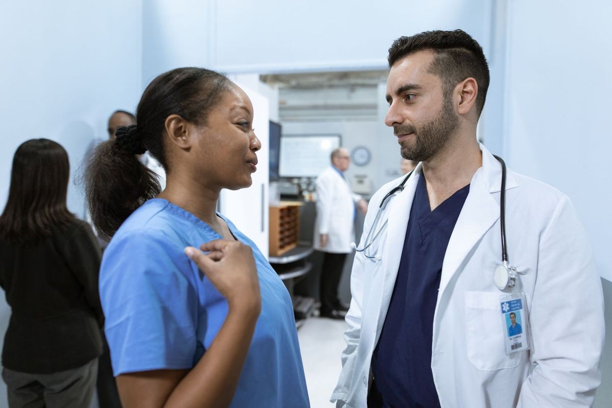 Professionnels de santé discutant dans un couloir d'hôpital Professionnels de santé discutant dans un couloir d'hôpital
