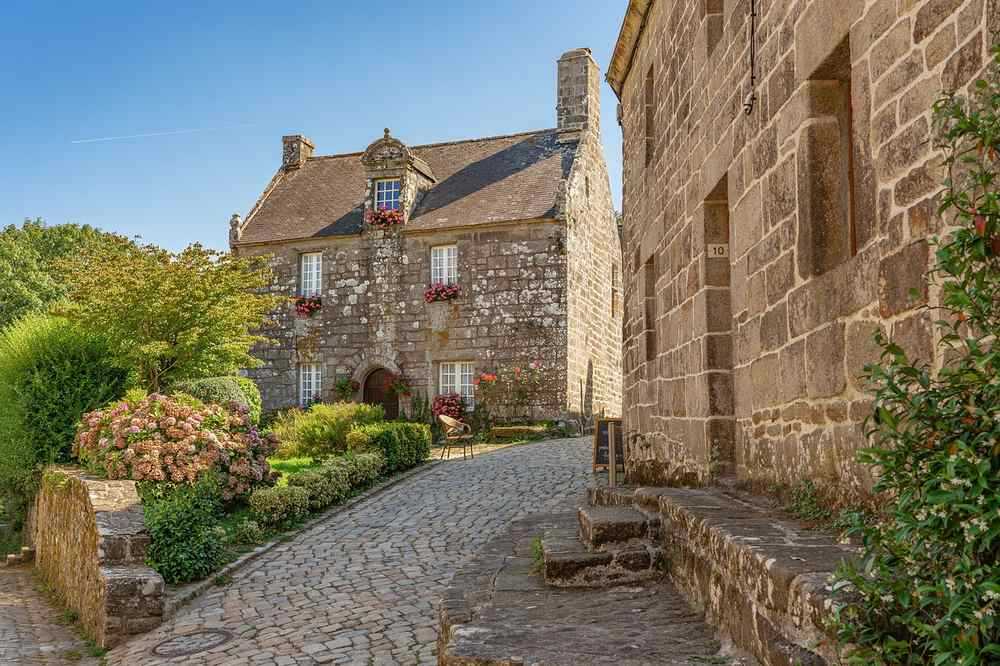 Ruelle pavée entre maisons en pierre, village côtier méditerranéen désert et calme