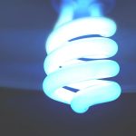 Une lampe compacte en forme de spirale émettant une lumière bleue vive