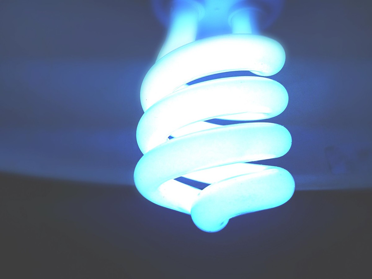 Une lampe compacte en forme de spirale émettant une lumière bleue vive