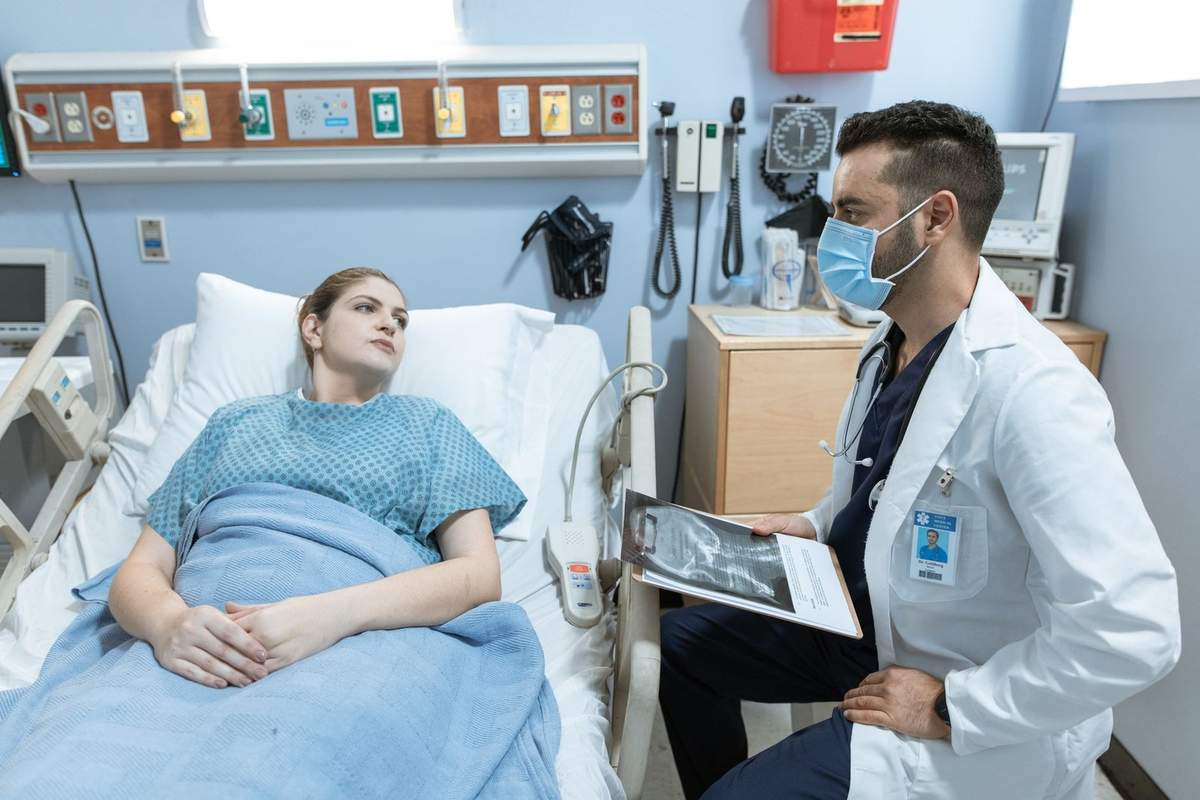 Femme dans un lit d'hôpital, médecin en blouse blanche avec document Femme dans un lit d'hôpital, médecin en blouse blanche avec document